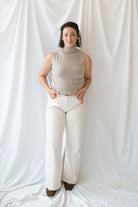 Model wearing the soft knit sleeveless turtleneck top. 