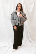 Black gingham quilted jacket for women featuring a classic checked pattern, textured quilted construction, and versatile everyday layering design.