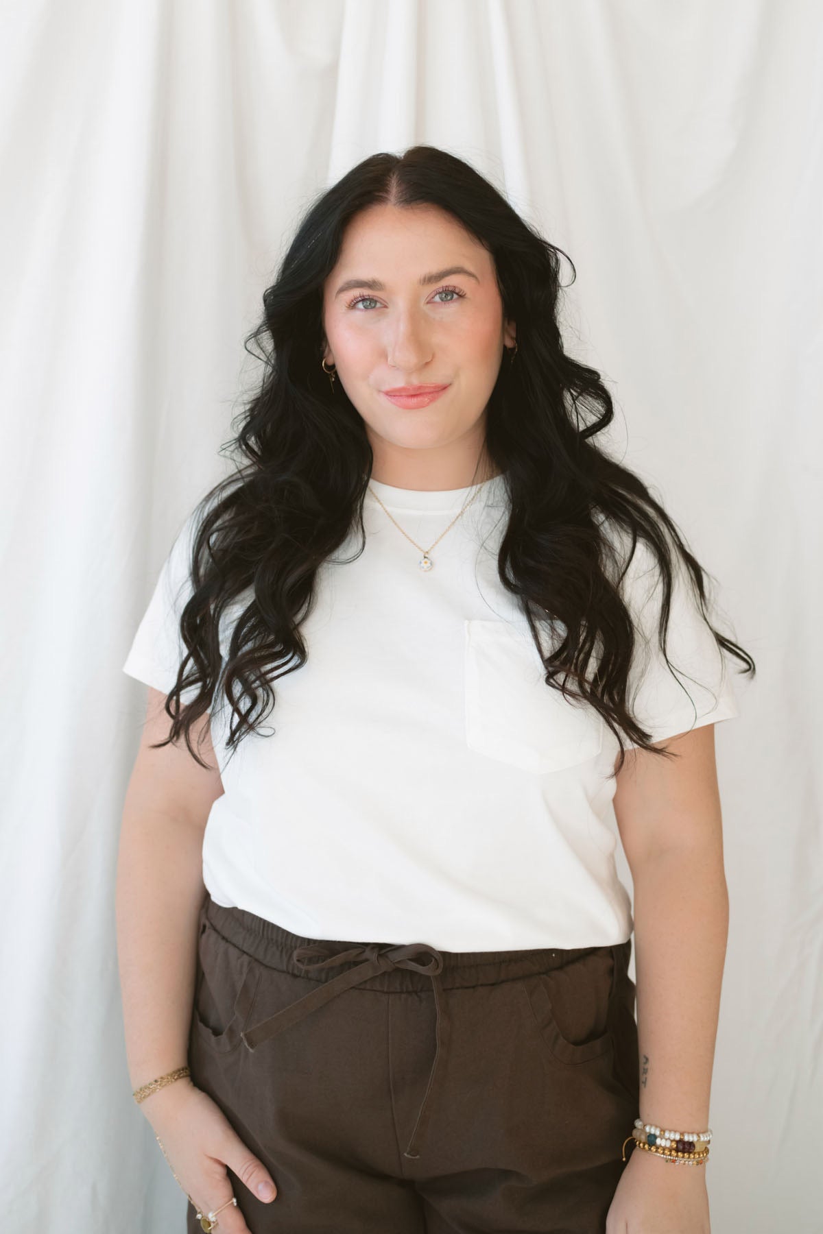 Model wearing basic white crew neck tee with pocket detail. 