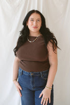 Model wearing the asymmetrical knit sweater sleeveless top with a dark pair of denim for a late summer early fall transition outfit. 