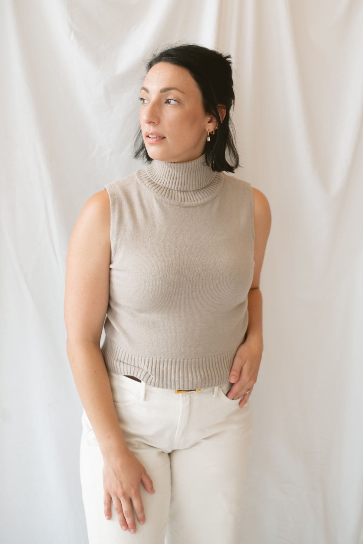 Model wearing the soft knit sleeveless turtleneck top. 