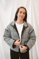 Black gingham quilted jacket for women featuring a classic checked pattern, textured quilted construction, and versatile everyday layering design.