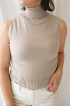 Model wearing the soft knit sleeveless turtleneck top. 