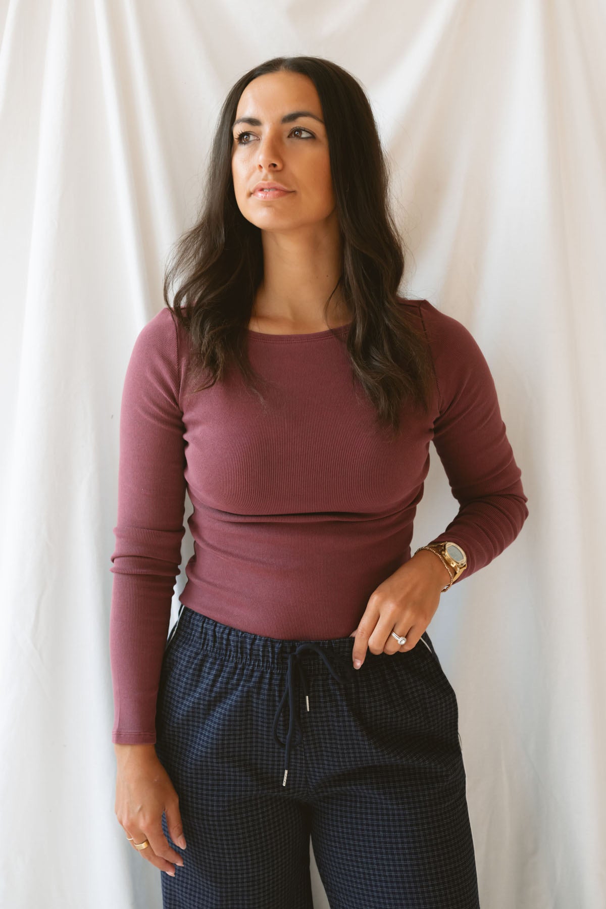 Model wearing ribbed long sleeve top with boat style neckline. Model has top styled with our navy checkered wide leg pants, but could be paired with a variety of bottoms. 