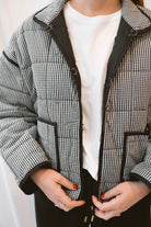 Black gingham quilted jacket for women featuring a classic checked pattern, textured quilted construction, and versatile everyday layering design.