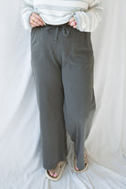 Model wearing cotton wide leg pants with drawstring waistband. Model has the pants styled with a lightweight sweater, but they can be paired with other basics tees or blouses. 