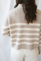 Carly light taupe striped knit sweater with a collared V-neckline and contrast trim.