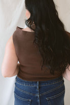 Model wearing the asymmetrical knit sweater sleeveless top with a dark pair of denim for a late summer early fall transition outfit. 
