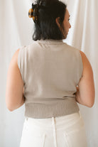 Model wearing the soft knit sleeveless turtleneck top. 