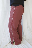 Jordan Finish Line women's track pants in Rosewood, featuring a muted earthy pink color and sporty casual silhouette for relaxed everyday outfits.