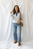 Model wearing pullover top in heather grey with denim collar detail.