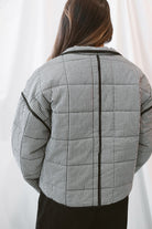 Black gingham quilted jacket for women featuring a classic checked pattern, textured quilted construction, and versatile everyday layering design.