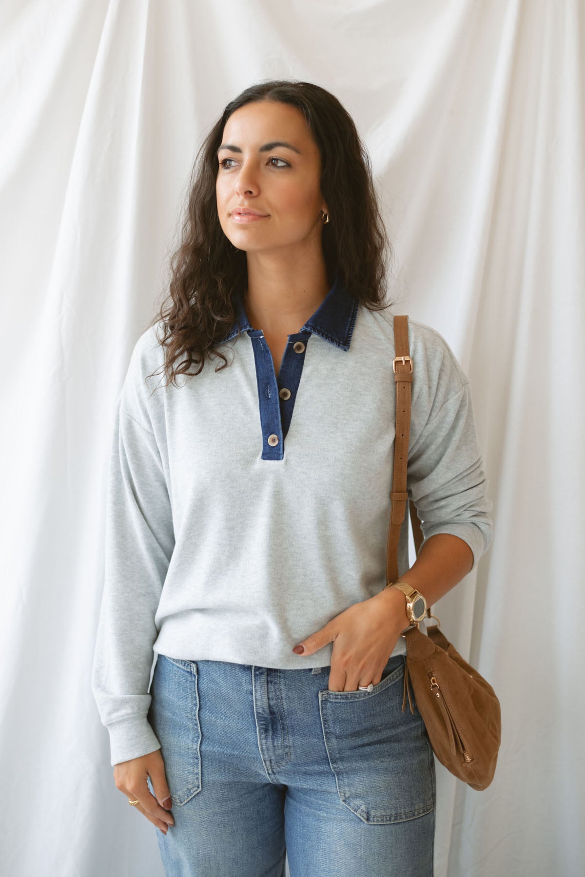 Model wearing pullover top in heather grey with denim collar detail.