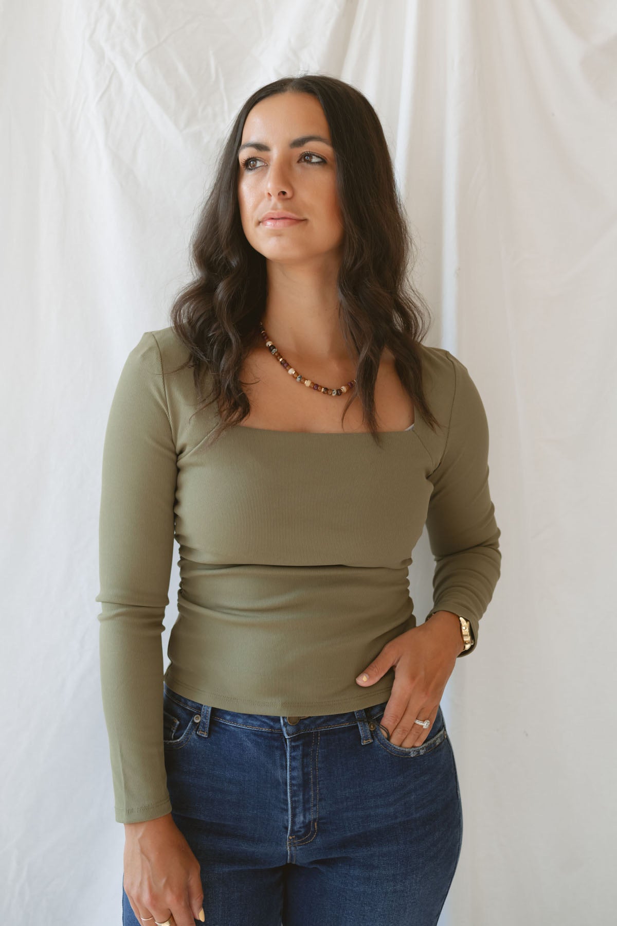 Model wearing the square neck long sleeve ruched side top in olive.