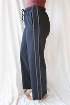 Side view of model wearing the drawstring check pants in navy. Easy to pair a variety of basic tops with now and into seasons ahead. 