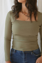 Model wearing the square neck long sleeve ruched side top in olive.