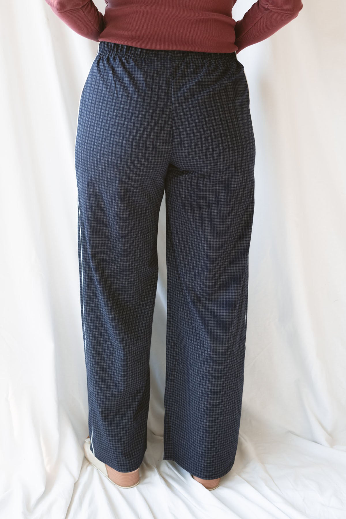 Back view of model wearing the drawstring check pants in navy. Easy to pair a variety of basic tops with now and into seasons ahead. 
