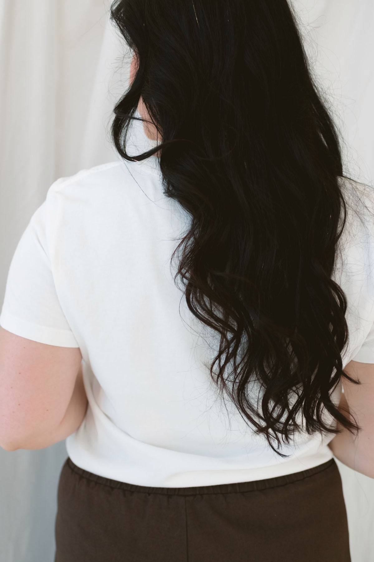 Model wearing basic white crew neck tee with pocket detail. 
