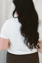 Model wearing basic white crew neck tee with pocket detail. 