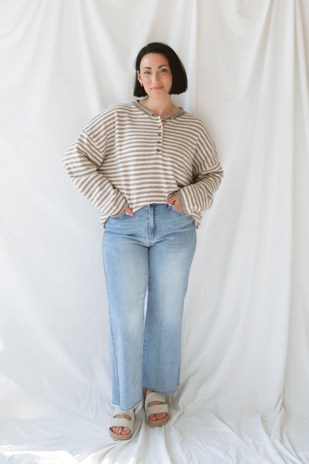 Model wearing the Quinn henley striped long sleeve sweater. 