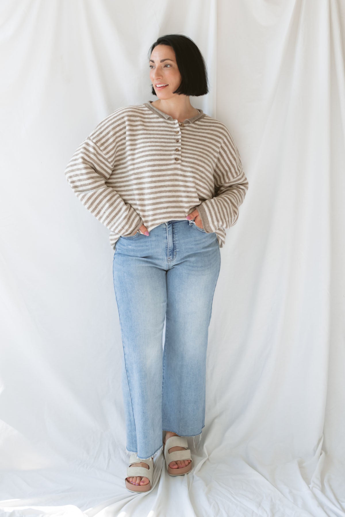 Model wearing the Quinn henley striped long sleeve sweater. 