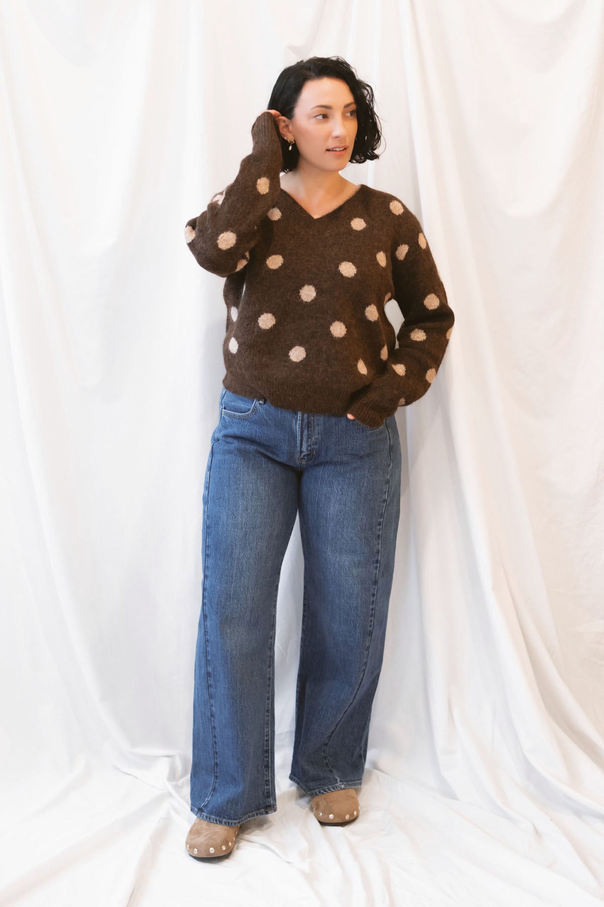 Dark wash stretch barrel-leg jeans for women featuring a subtle curved leg silhouette, twisted seam detailing, and a modern relaxed denim design.
