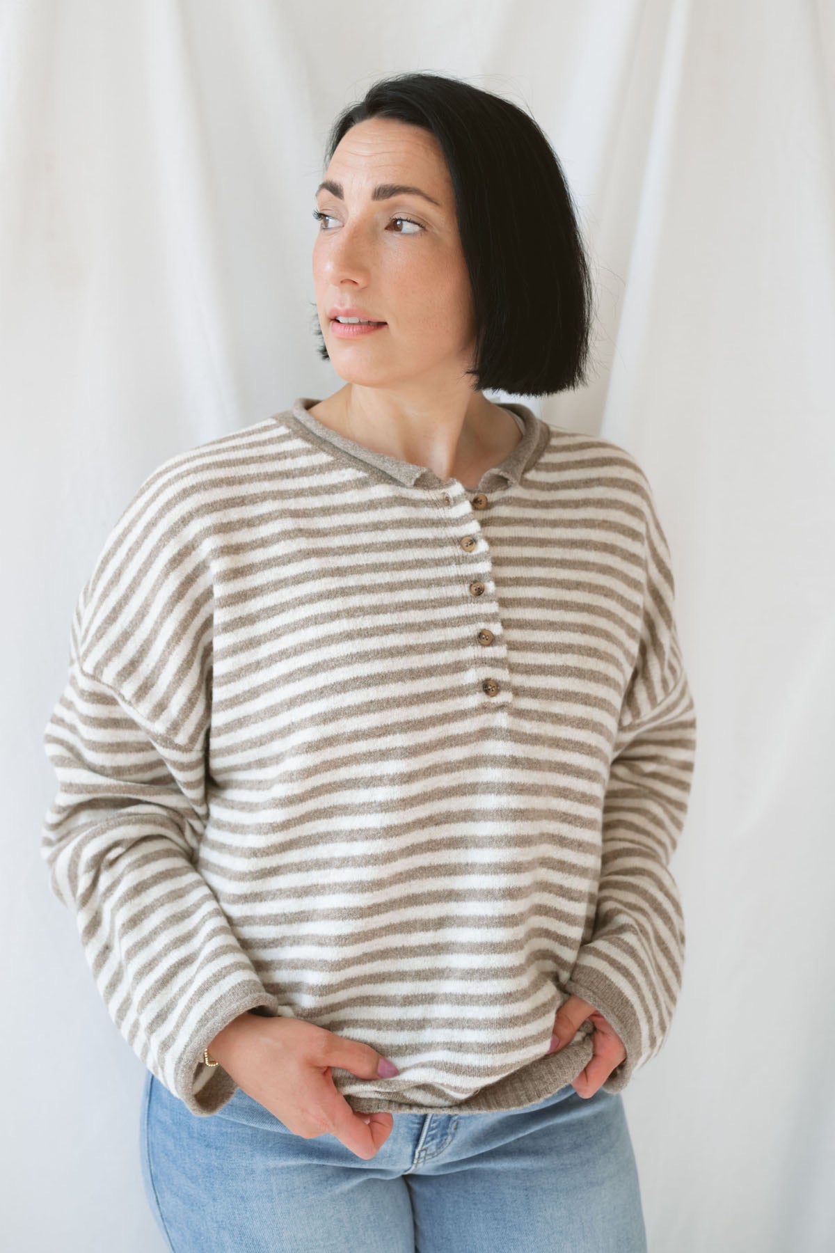 Model wearing the Quinn henley striped long sleeve sweater. 