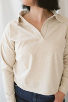 Model is wearing the knit polo sweater in the color beige.  