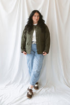 Model is wearing the lapel collar quilted jacket in olive. 