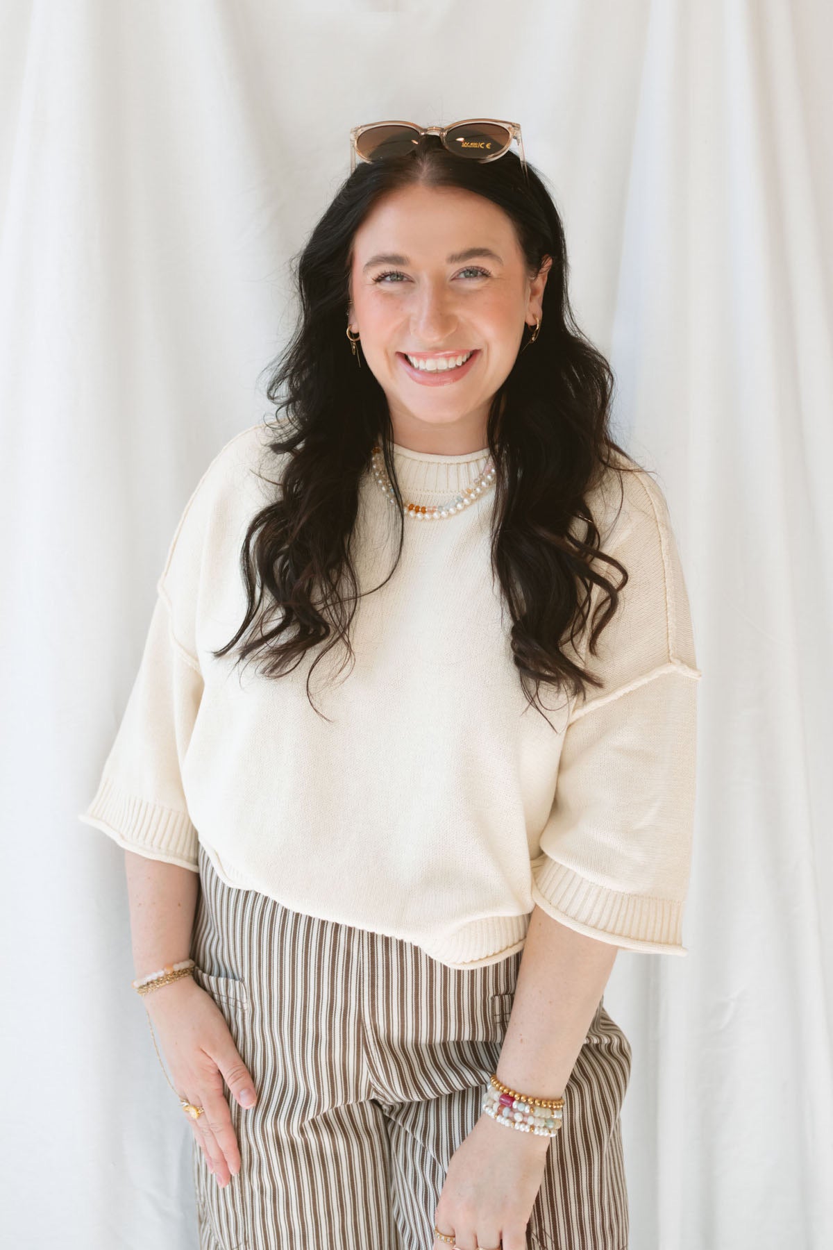 Model wearing the drop sleeve exposed seam sweater short sleeve top. This top is very versatile, styling it during warm months with shorts of any kind and in the cooler months with long pants and eventually layering under jackets and blazers. 