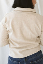 Model is wearing the knit polo sweater in the color beige.  