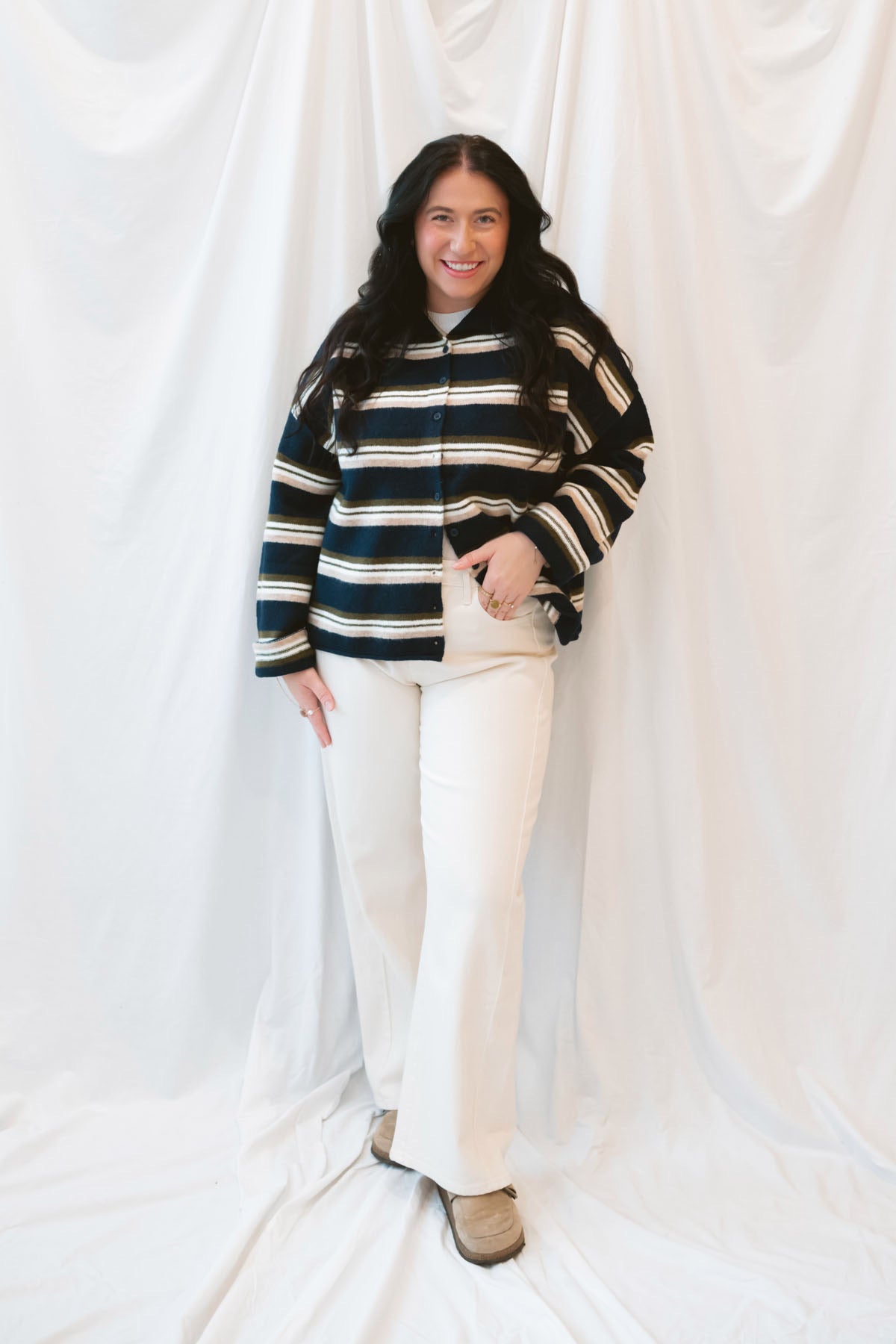 Model wearing navy stripe and multi colored button up cardigan. 