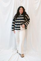 Model wearing navy stripe and multi colored button up cardigan. 