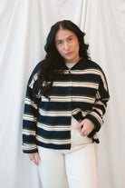Model wearing navy stripe and multi colored button up cardigan. 