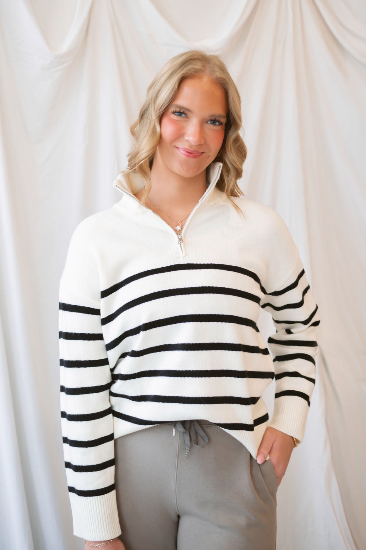 Maggie Striped Half Zip Mock Neck Knit Sweater Top in Cream and Black featuring a striped pattern and half-zip neckline.