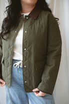 Model is wearing the lapel collar quilted jacket in olive. 