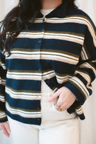 Model wearing navy stripe and multi colored button up cardigan. 
