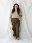 Model wearing the amora stripe short sleeve top paired with the Stevie linen texture pants in brown. 