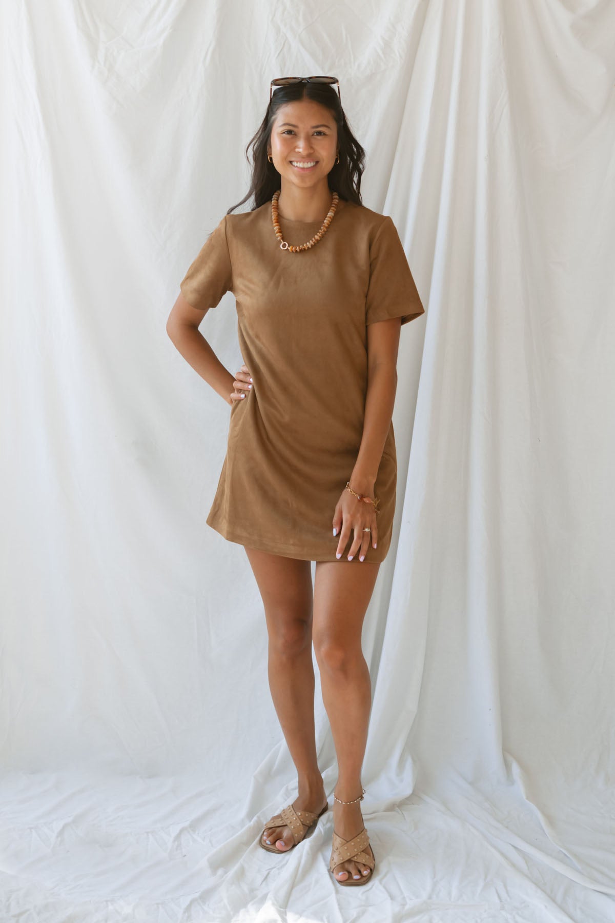Model wearing the faux suede mini t-shirt style dress. A casual option that can be dressed up with boots and jewelry. 
