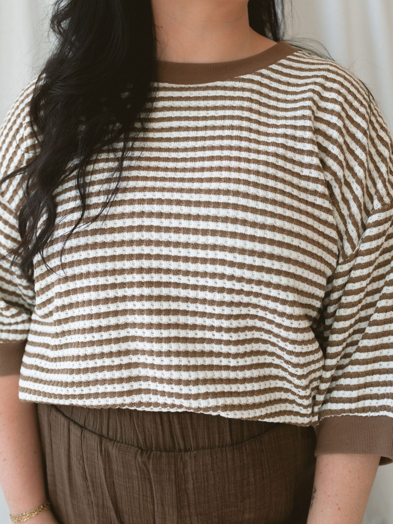 Close up view of model wearing the amora stripe short sleeve top.
