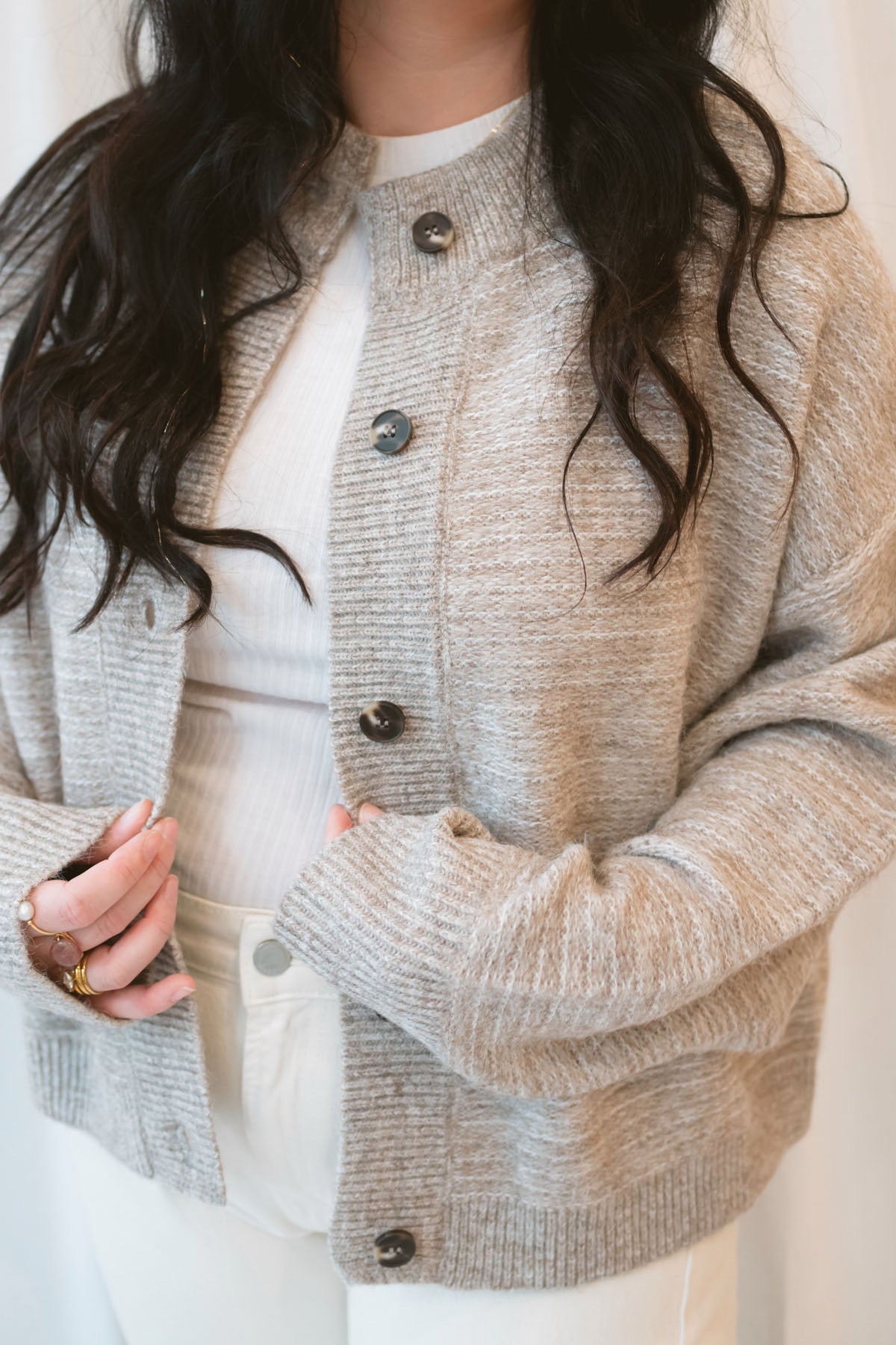 Model wearing boxy fit button up cardigan in latte tan. 