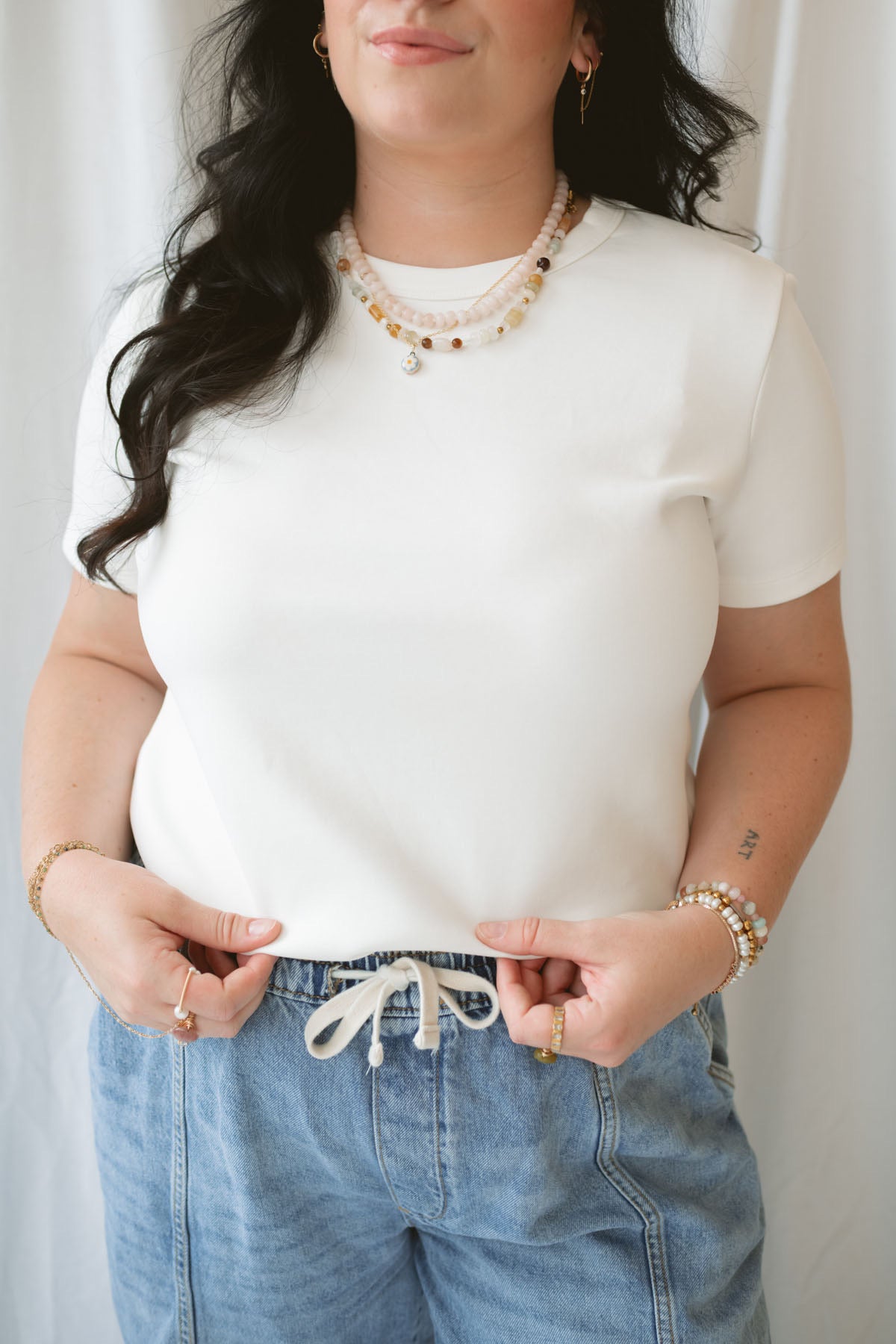 Model wearing round neck short sleeve top.