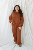 Model is wearing the oversized rust colored hoodie sweatshirt. 