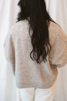 Model wearing boxy fit button up cardigan in latte tan. 
