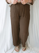 Model wearing brown linen blend pants with elastic waistband. 