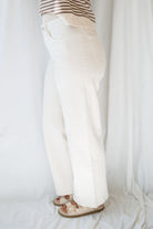 Model wearing the high rise stretch barrel denim pants in off white. 
