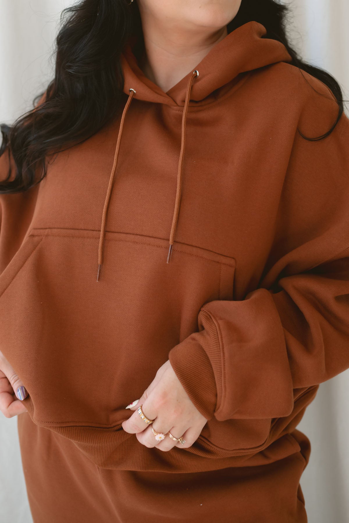 Model is wearing the oversized rust colored hoodie sweatshirt. 