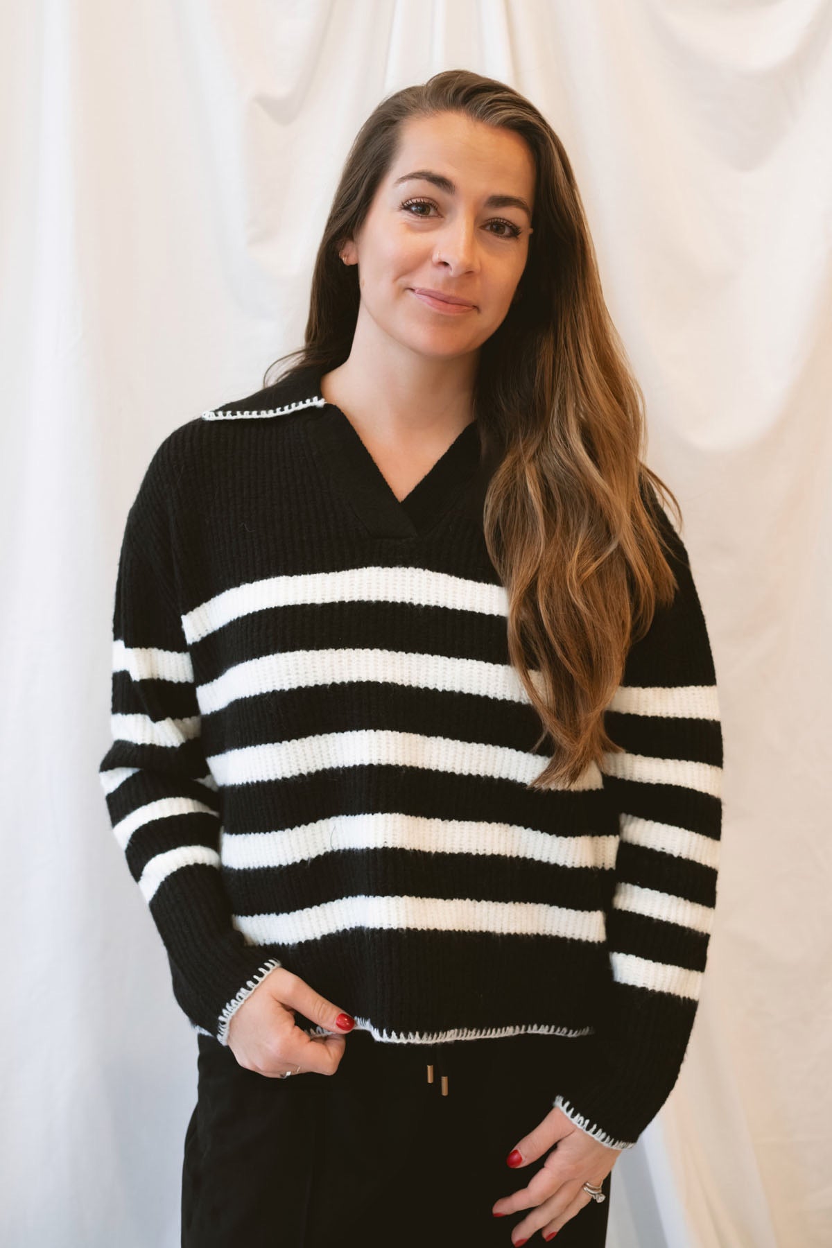 Black striped knit sweater top for women featuring a collared V-neckline, contrasting trim, and classic preppy-inspired design for elevated everyday styling.