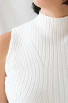 Close up of model wearing the ribbed sleeveless high neck top in off white. A staple for your wardrobe from season to season. 