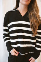 Black striped knit sweater top for women featuring a collared V-neckline, contrasting trim, and classic preppy-inspired design for elevated everyday styling.